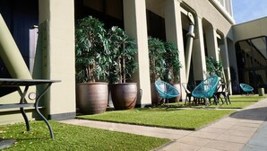 Un cortile con piante in vaso, posti a sedere all'aperto e un vialetto.