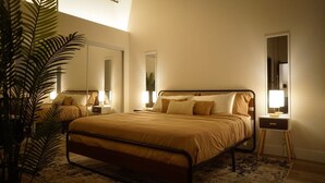 A bedroom with a bed, bedside tables, a mirror, and a potted plant. - New York Style Home 10 Minutes To SNA Disneyland (Santa Ana)