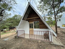 A small, triangular-shaped building with a wooden roof and a single window.