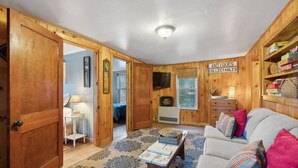 Une pièce confortable avec un canapé, un téléviseur et une pancarte indiquant « ANTIQUITÉS ET OBJETS DE COLLECTION ».