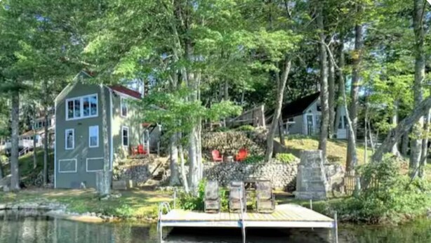 Une propriété au bord du lac, comprenant un quai, une maison et une construction en pierre.