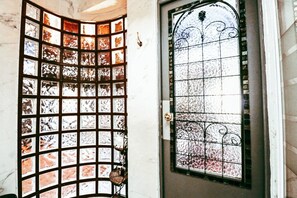 Une porte ornĂ©e dâun panneau de verre dĂ©coratif et dâun portail en mĂ©tal.