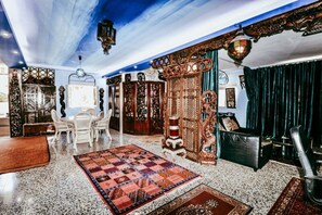 A room with a dining area, a patterned rug, and traditional decor.