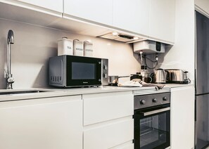 Een koelkast, een oven, een kookplaat, een koffiezetapparaat/waterkoker