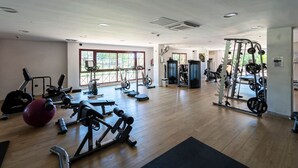 A spacious gym with various exercise equipment, large windows, and a wooden floor. - Mirador Marbella | Pool | Golf | Gym | Sauna (Ojén)