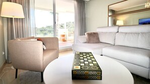 A modern hotel room with a grey sofa, a beige armchair, and a round coffee table. - Mirador Marbella | Pool | Golf | Gym | Sauna (Ojén)