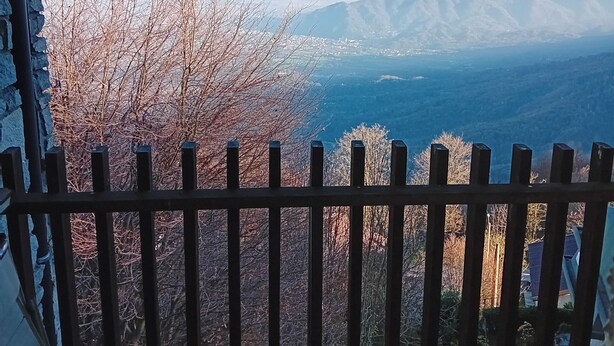 A view through a window with a wooden railing, featuring a mountainous landscape and leafless trees. - PANORAMIC EAGLE - The mountains, 5 minutes from the shops (Montoso)