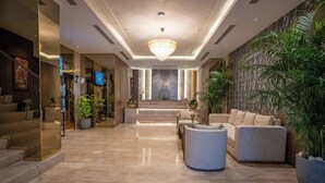 A spacious lobby with a marble floor, a large chandelier, and a seating area with a sofa and armchairs. - ASTER GRAND BY ZENQ SAKET (New Delhi)