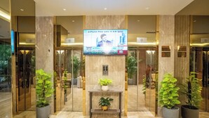 A modern lobby with a digital display, marble flooring, and potted plants. - ASTER GRAND BY ZENQ SAKET (New Delhi)