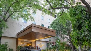A modern hotel entrance with a car parked in front. - ASTER GRAND BY ZENQ SAKET (New Delhi)