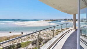 A balcony with a view of a beach and ocean.