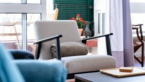 A modern living room with a grey armchair, a blue sofa, and a wooden coffee table. - GuestReady - Wake Up to the Heartbeat of Madeira (Funchal)