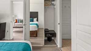 A hotel room with a bed, a desk, and a walk-in closet. - 1BR Free Shuttle to Disney Parks (Orlando)