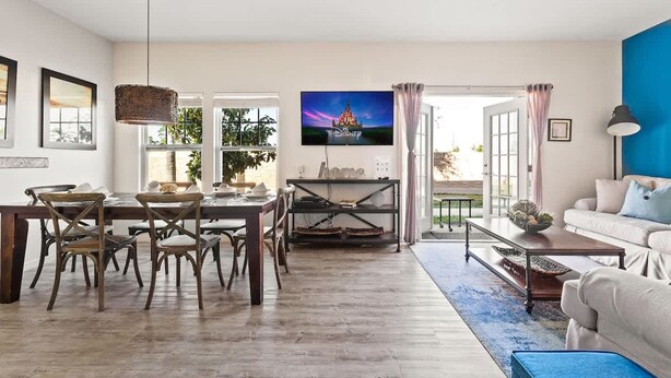 A spacious living area with a dining table, chairs, a television, and a sofa. - Modern Decor at West Lucaya 4 BR Wl8989 (Kissimmee)