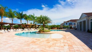 A pool area with lounge chairs and palm trees, surrounded by buildings. - Modern Decor at West Lucaya 4 BR Wl8989 (Kissimmee)