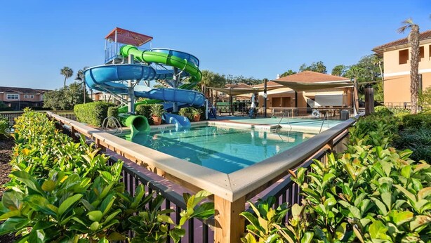 A pool area with a water slide and a pool.
