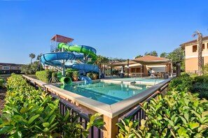 Un espace piscine comprenant un toboggan aquatique et une piscine.