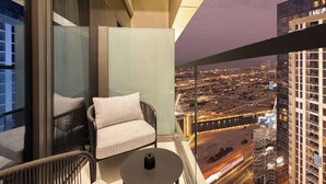 Un balcón con sofá y mesa, con vistas a un paisaje urbano nocturno.