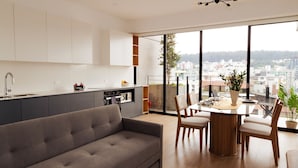 Una cocina moderna con comedor, ventanas amplias y vista a la ciudad.