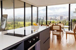 Una cucina moderna con un'ampia finestra, un'area pranzo con tavolo e sedie, e vista sulla città.