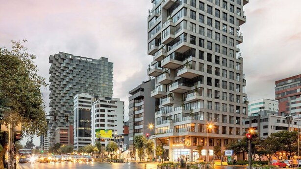 Un moderno edificio de gran altura con múltiples balcones y fachada de vidrio.
