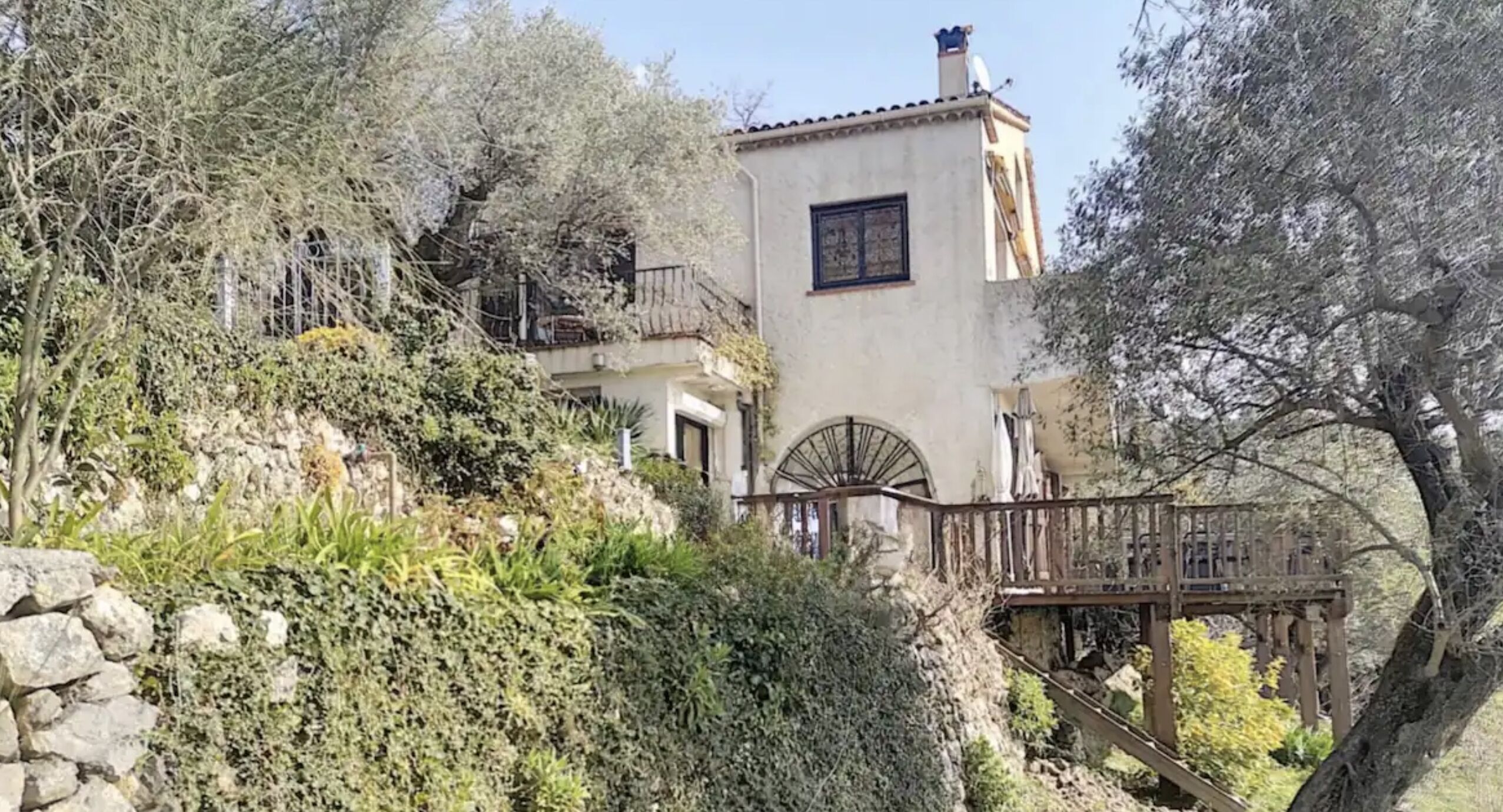 Edifici tradicional amb una escalinata de pedra que condueix a un pont de fusta.