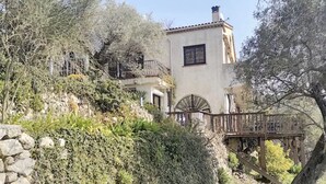 A traditional building with a stone staircase leading to a wooden bridge.