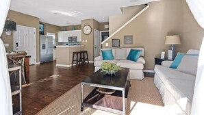 A spacious living area with a kitchen in the background, a staircase, and a dining area. - Charming Townhouse 4 BR up to 12 People Wl8972 (Kissimmee)