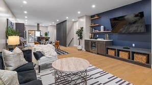 Ein modernes Wohnzimmer mit Sofa, Couchtisch und einer TV-Wand.