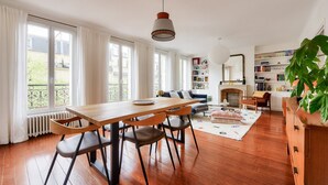 Un salon spacieux avec une table à manger en bois, un canapé et une cheminée.