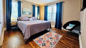 A bedroom with a bed, a ceiling fan, a window with curtains, a rug, and a chair. - Charming House in Midtown Memphis near Beale St and St Jude  (Memphis)