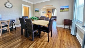 A dining area with a wooden table and chairs, a ceiling fan, and a clock on the wall. - Charming House in Midtown Memphis near Beale St and St Jude  (Memphis)