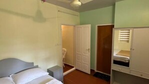 A bedroom with a bed, a wardrobe, a door, and a ceiling fan. - Eco-Friendly Plantation Retreat Near Thekkady (Anakkara)