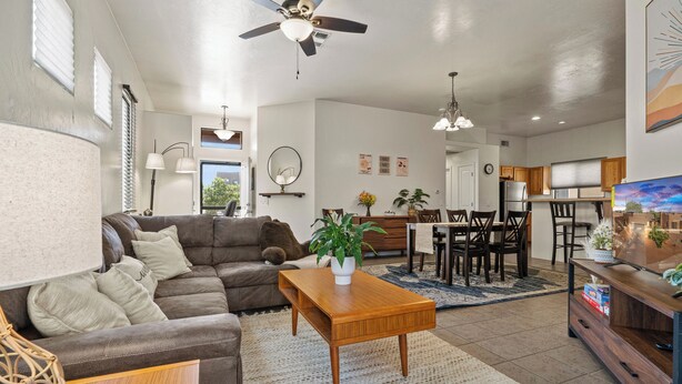 A spacious living room with a brown leather sofa, a wooden coffee table, and a dining area with a wooden table and chairs. - Cozy/Relaxing Home in Sierra Vista (Sierra Vista)