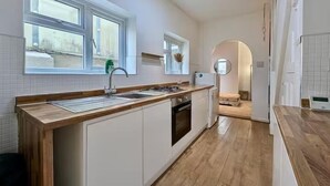 A modern kitchen with a wooden countertop, white cabinets, and a built-in oven.