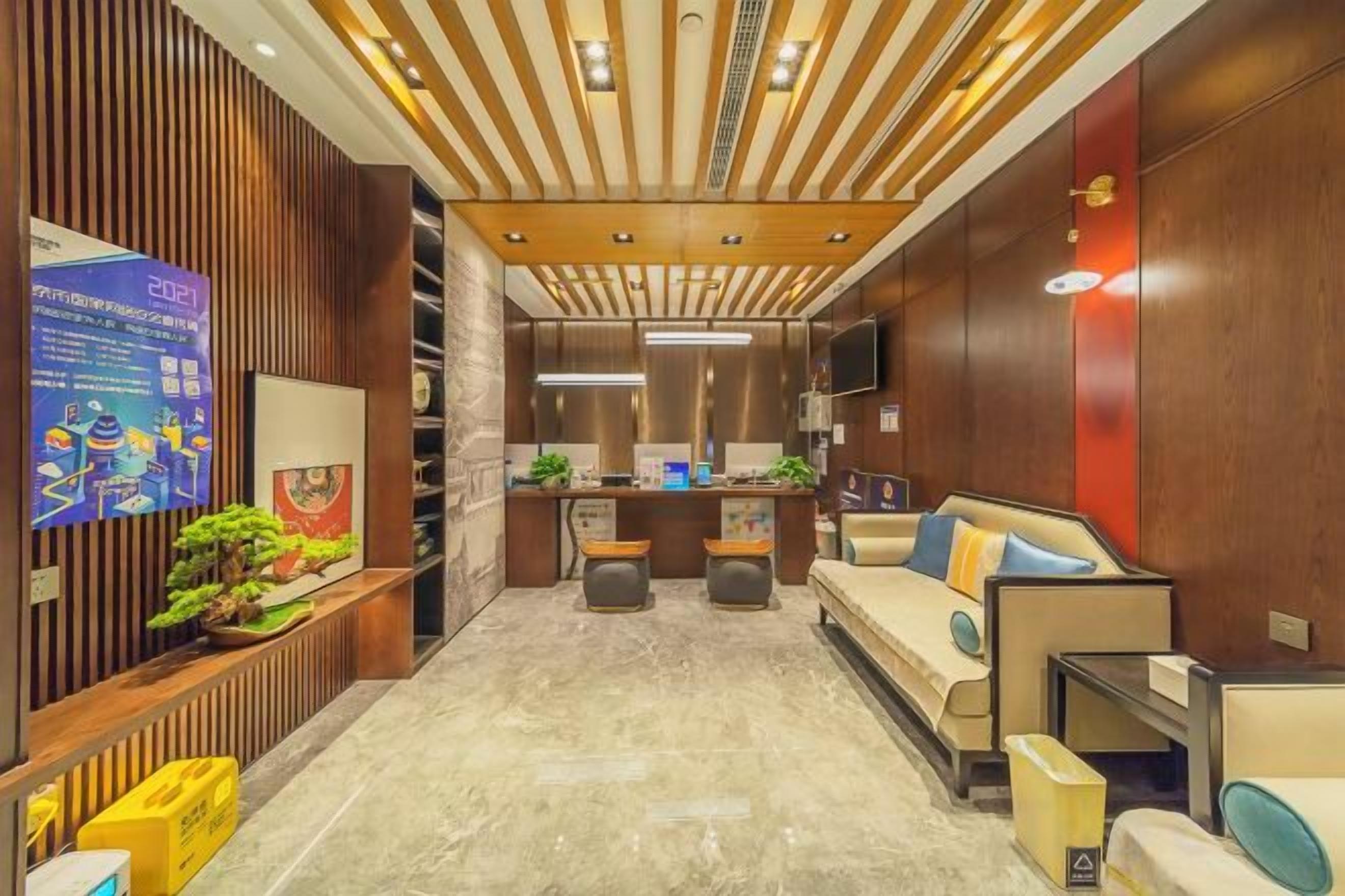 A hotel lobby with a reception desk, seating area, and a wooden accent wall.
