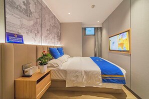A hotel room with a bed, a desk, a TV, and a wall with artwork. - Super 8 Hotel (Beijing Tian'anmen Wangfujing Pedestrian Street) (Beijing)