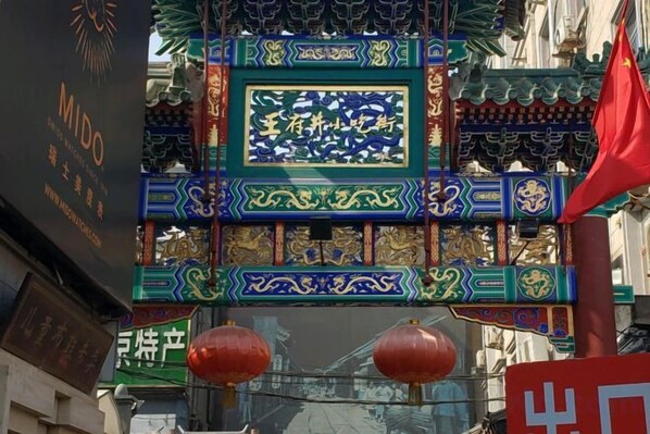 A traditional Chinese gate with intricate designs and a red flag.