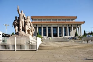 A building with a classical architectural style, featuring a central statue on a pedestal, large windows, and a paved entrance area. - Super 8 Hotel (Beijing Tian'anmen Wangfujing Pedestrian Street) (Beijing)
