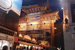 Um edifício tradicional com arquitetura ornamentada, um relógio e uma placa com caracteres chineses.