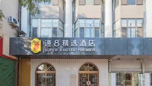 The exterior of Super 8 Hotel Premier with a prominent sign, large windows, and a modern facade.
