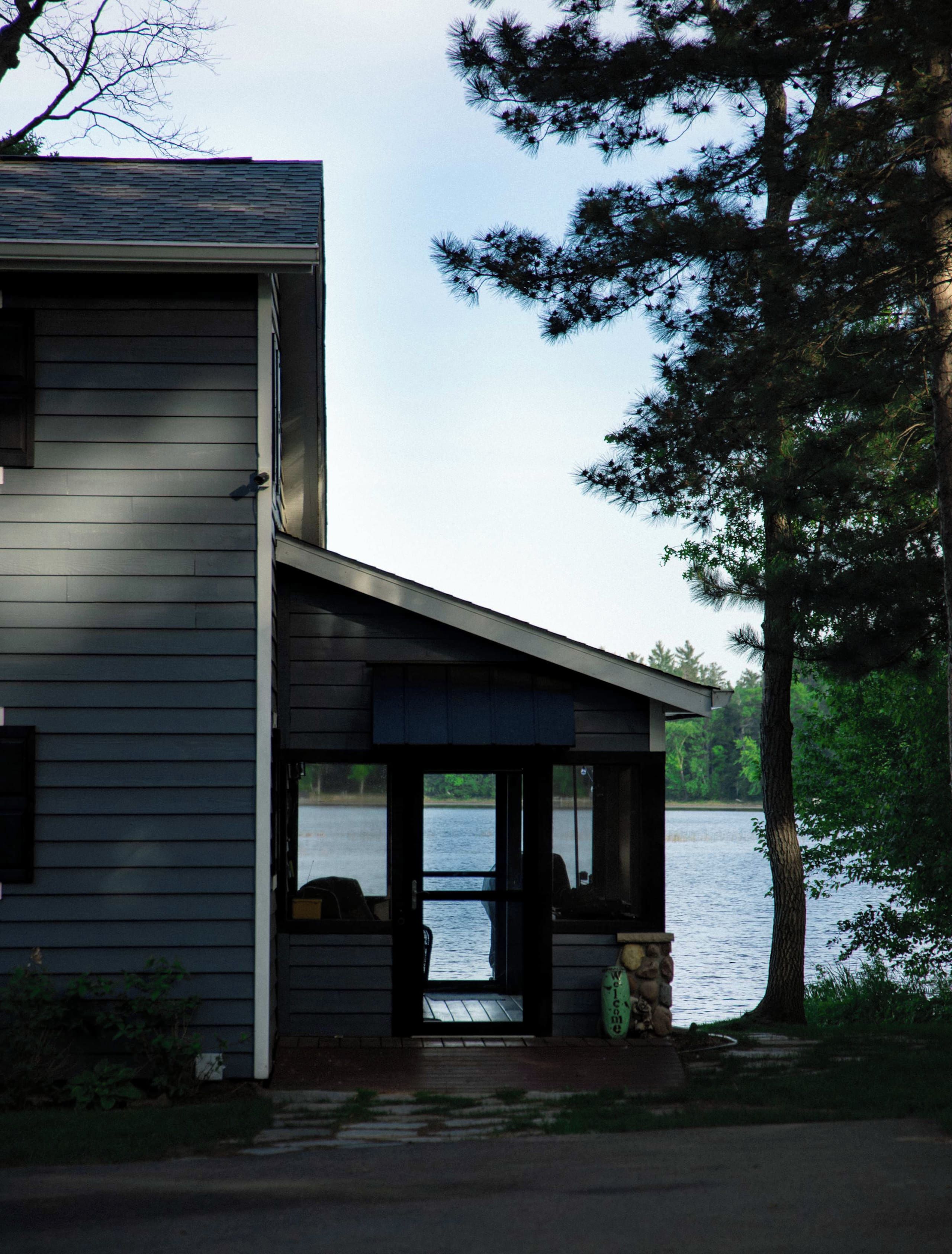 Ein modernes Haus mit einer Veranda mit Blick auf einen See.