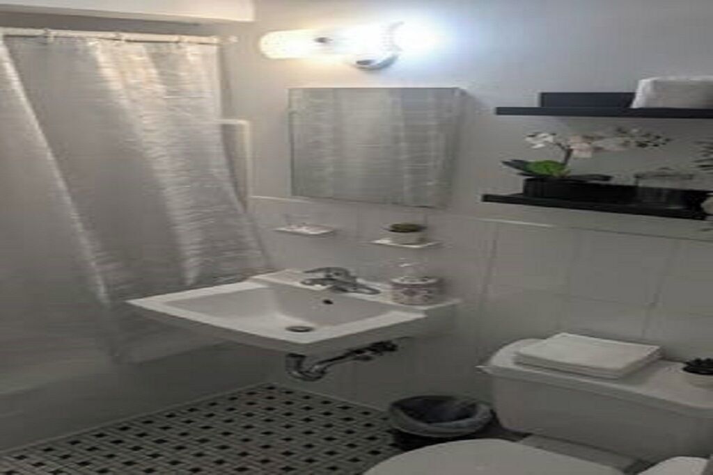 A bathroom with a sink, toilet, and shower curtain.