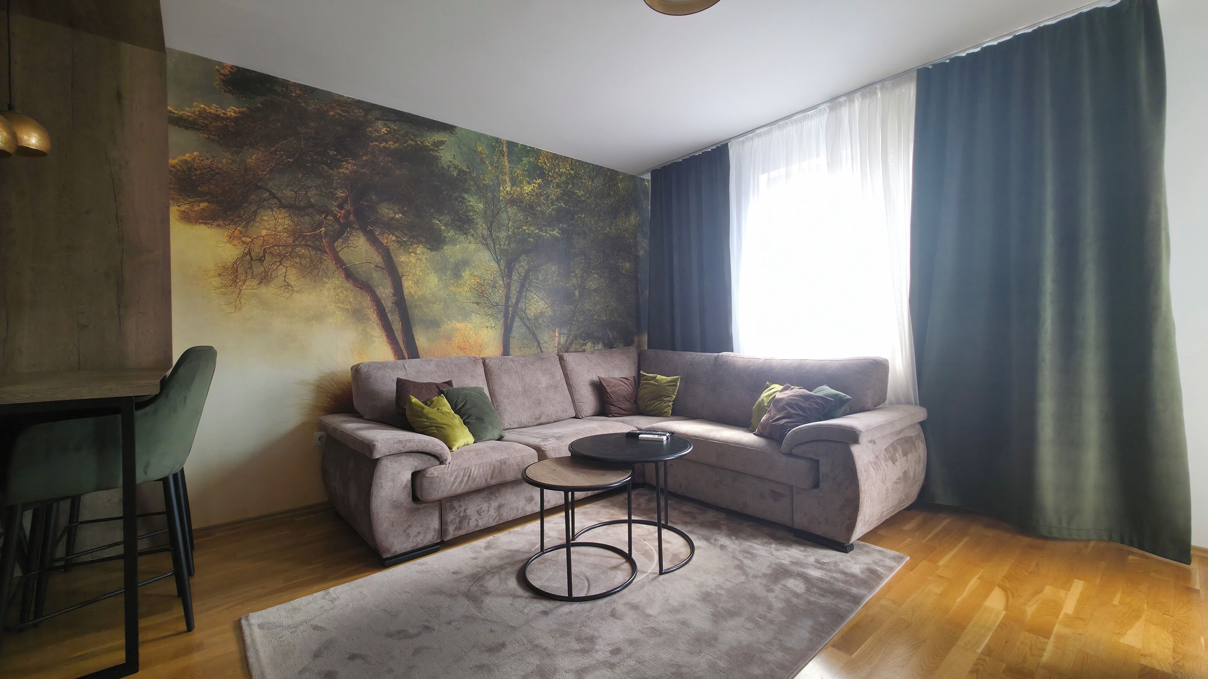 Una sala de estar con un sofá modular, una mesita redonda y un sillón verde.
