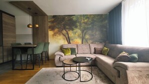 Een moderne woonkamer met een hoekbank, een kleine ronde tafel en een eethoek met stoelen.