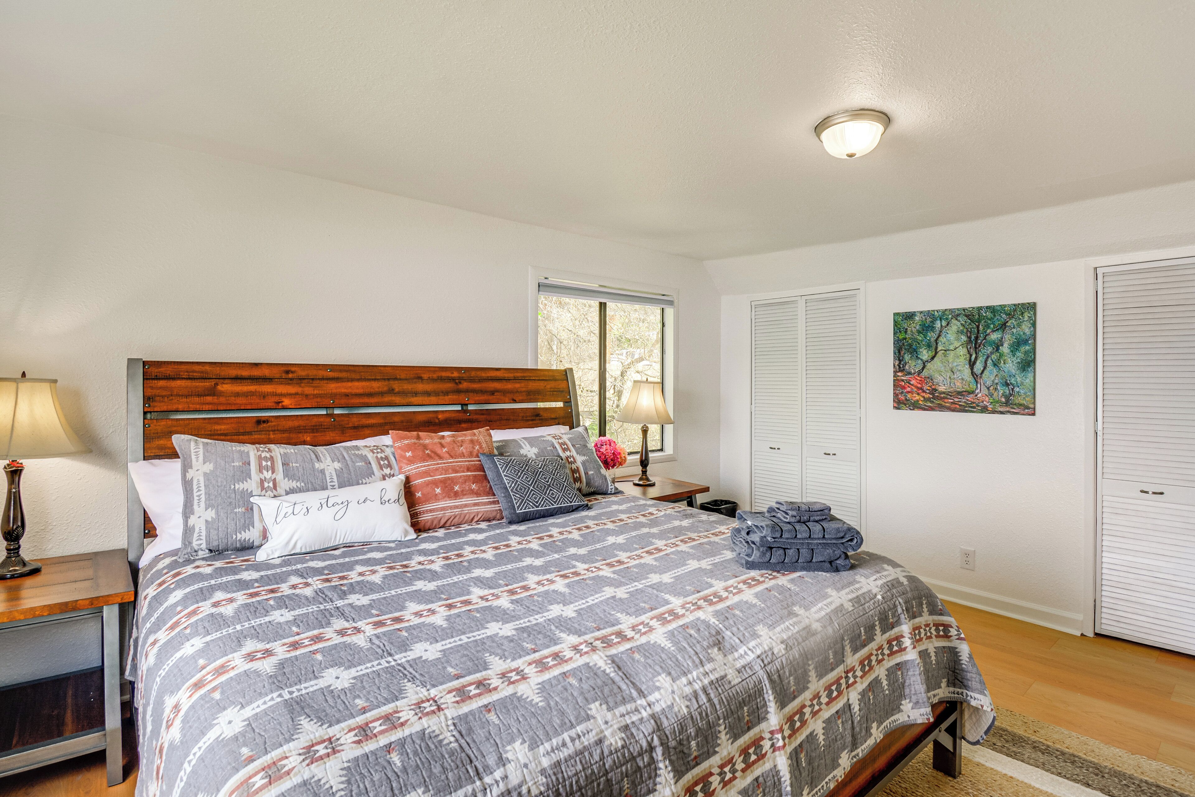 Une chambre à coucher avec une tête de lit en bois, une couvre-lit à motifs et une table de chevet avec une lampe.