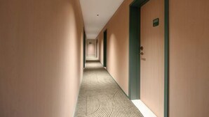 A corridor with doors on one side and a carpeted floor. - Hi Inn (Beijing Tiananmen National Grand Theater) (Beijing)