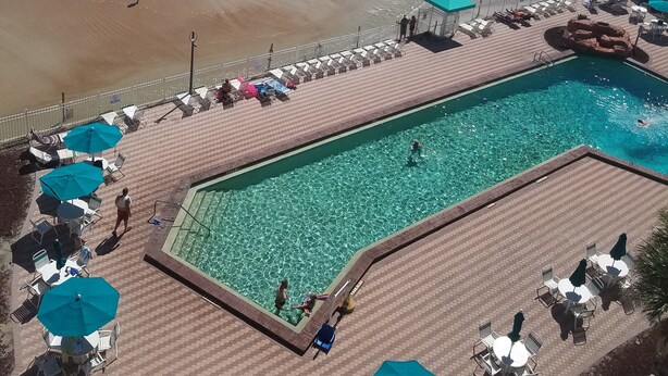 Zona de piscina con vista a la playa y al océano.