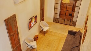 Ein großzügiger Wohnbereich mit Sofa, Sesseln, Kamin und Treppe.