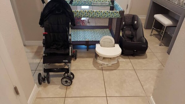 A small bathroom with a toilet, a baby changing station, and a stroller. - Themed Mickey Bedroom 4BR at Solterra (Davenport)